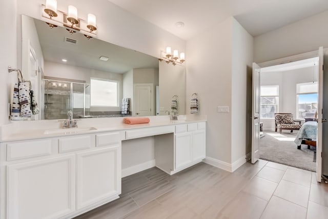 ensuite bathroom with double vanity, visible vents, a stall shower, a sink, and baseboards