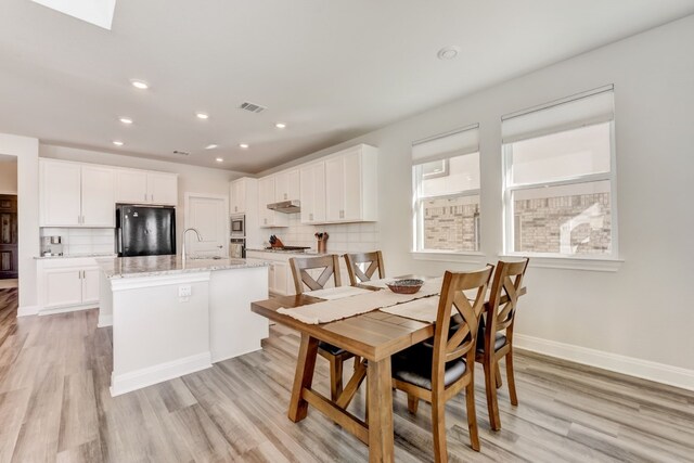 dining area with light wood-style flooring, recessed lighting, visible vents, and baseboards