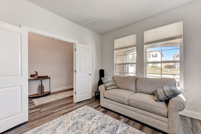 living area with baseboards, wood finished floors, and visible vents