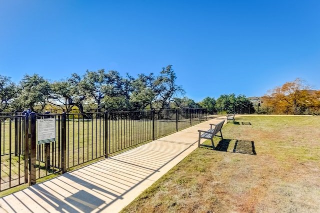 view of community with fence and a lawn