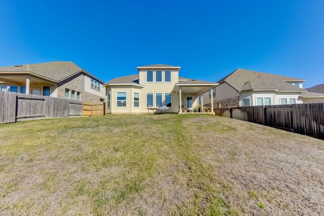 back of property featuring a lawn and a fenced backyard