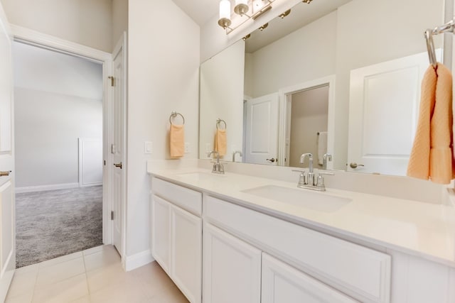 full bathroom featuring double vanity, tile patterned flooring, a sink, and baseboards