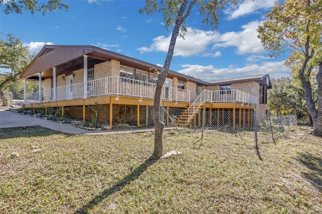 back of house featuring a wooden deck and a lawn