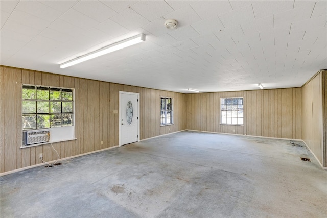 spare room with cooling unit and wood walls