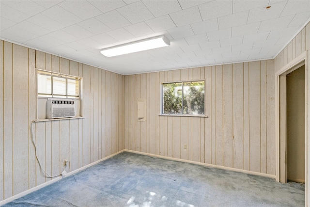 unfurnished room featuring cooling unit, carpet floors, and wooden walls