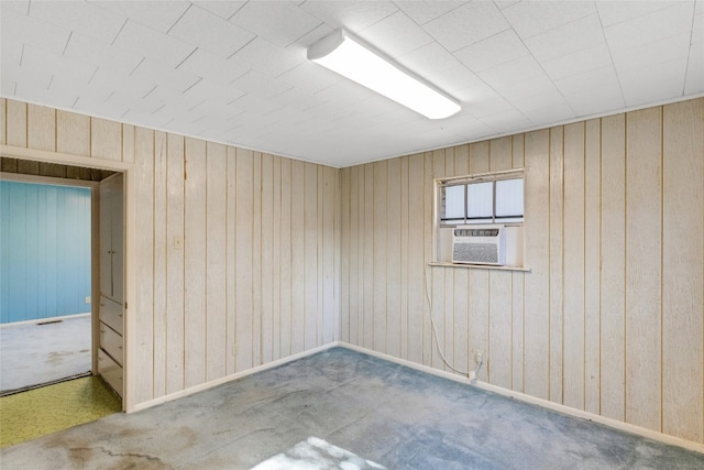 carpeted spare room featuring cooling unit and wooden walls