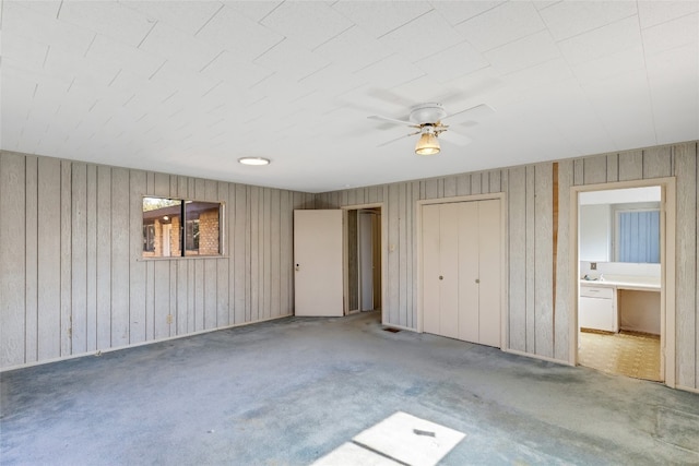 unfurnished bedroom with connected bathroom, carpet flooring, and ceiling fan