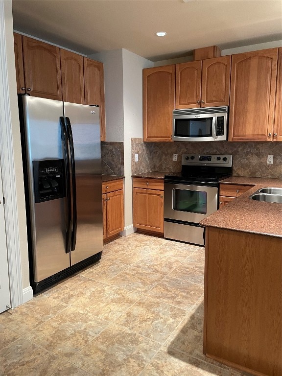 kitchen featuring sink, decorative backsplash, light tile patterned floors, and stainless steel appliances