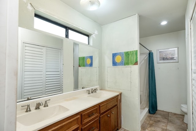 bathroom with a shower with curtain, vanity, toilet, and tile patterned floors