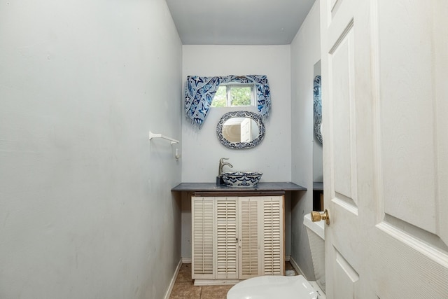 bathroom with sink, toilet, and tile patterned floors