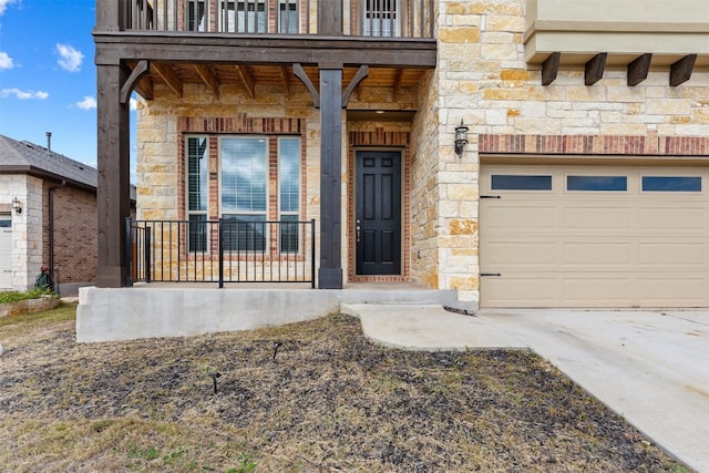 view of exterior entry with a balcony and a garage