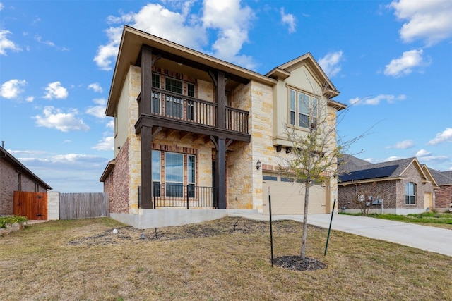 view of front facade featuring a balcony, a front yard, solar panels, and a garage