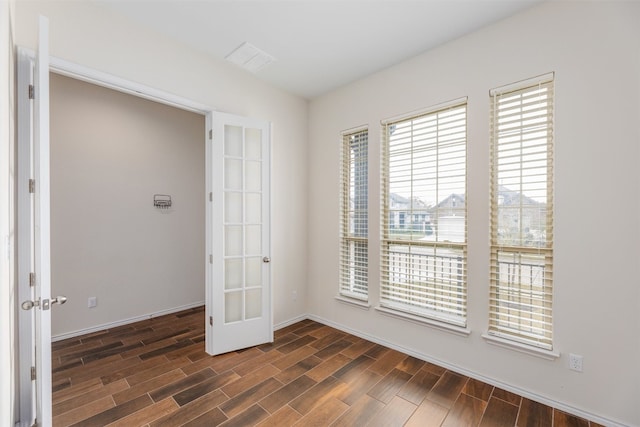 spare room with french doors and dark hardwood / wood-style flooring