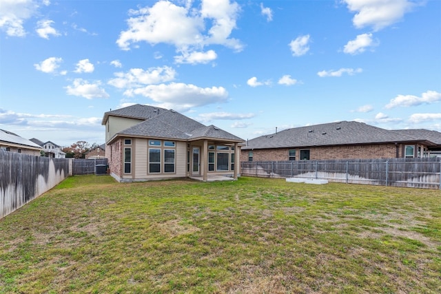 rear view of property featuring a patio and a yard