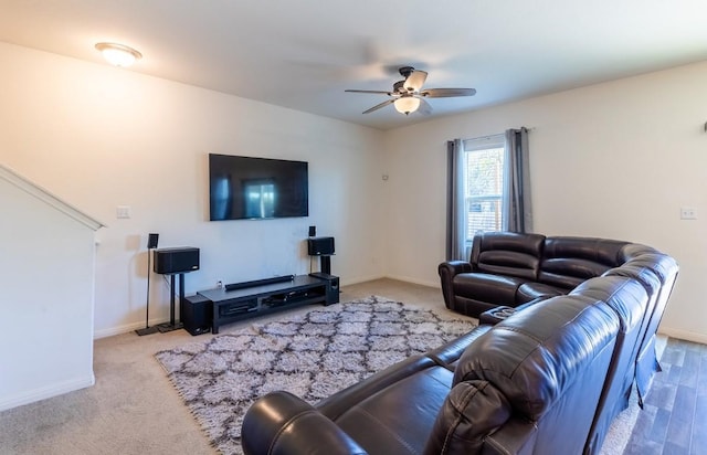 living room with carpet flooring, baseboards, and a ceiling fan