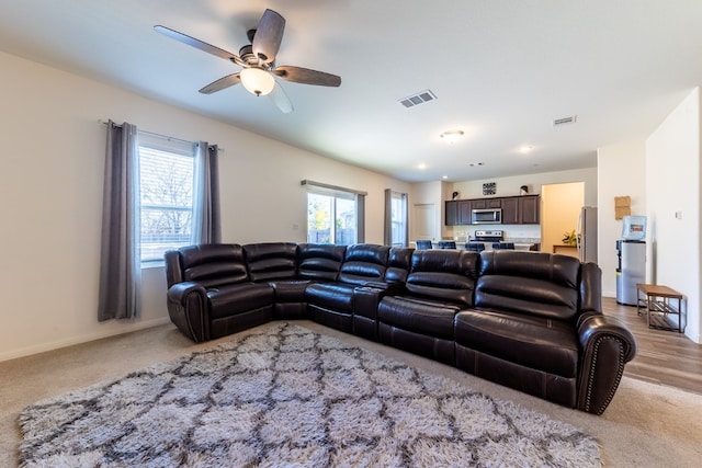 living room featuring ceiling fan and light hardwood / wood-style flooring