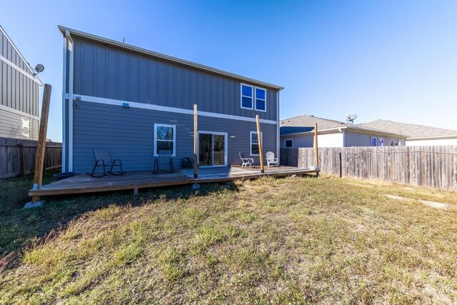 rear view of property with a lawn and a deck