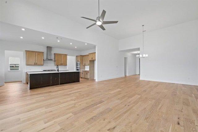 unfurnished living room featuring light hardwood / wood-style floors and ceiling fan with notable chandelier