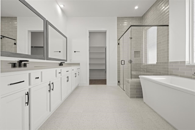 bathroom featuring tile walls, vanity, and plus walk in shower