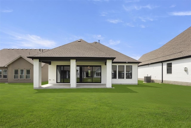 rear view of property featuring central AC unit, a lawn, and a patio area