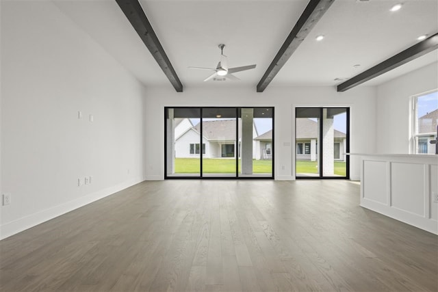 empty room featuring ceiling fan, beam ceiling, and dark hardwood / wood-style flooring