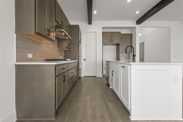 kitchen with beamed ceiling, tasteful backsplash, sink, and dark hardwood / wood-style floors