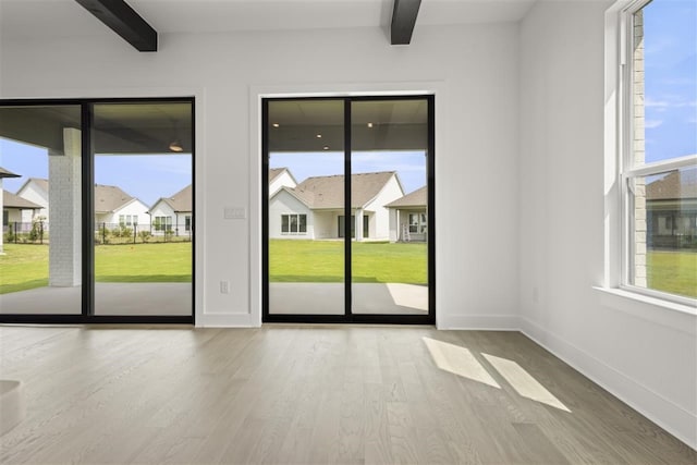 entryway with beamed ceiling and light wood-type flooring