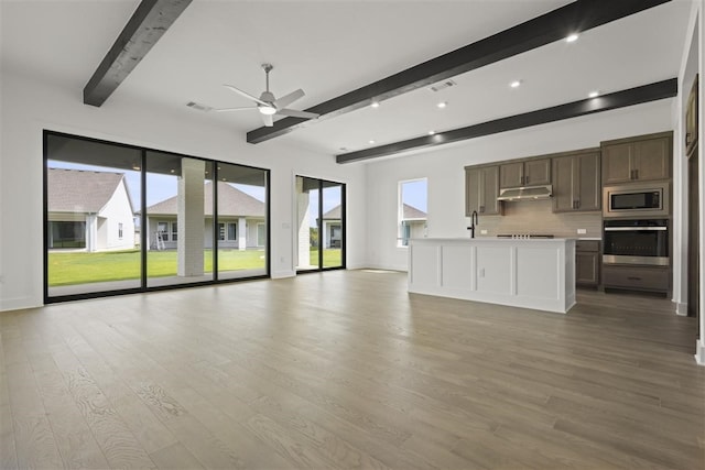 unfurnished living room featuring light hardwood / wood-style flooring, a wealth of natural light, ceiling fan, and beam ceiling