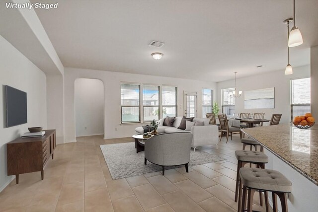 living room featuring light tile patterned floors and a notable chandelier