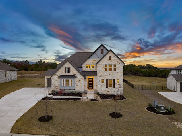 view of front facade featuring metal roof, fence, driveway, a front lawn, and a standing seam roof