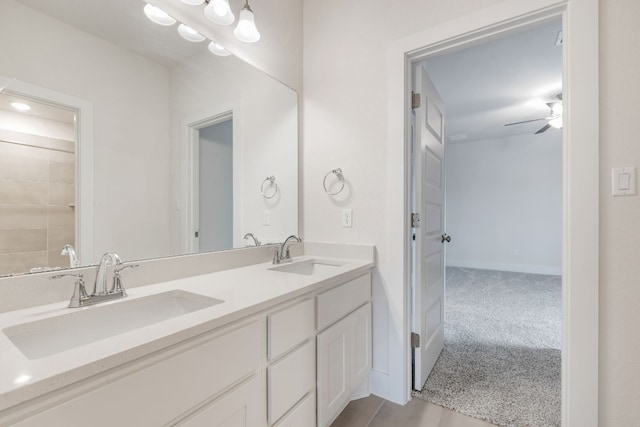 bathroom featuring double vanity, a ceiling fan, baseboards, and a sink