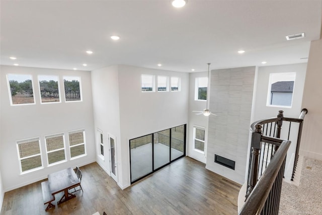 living room with wood finished floors, a tile fireplace, and visible vents