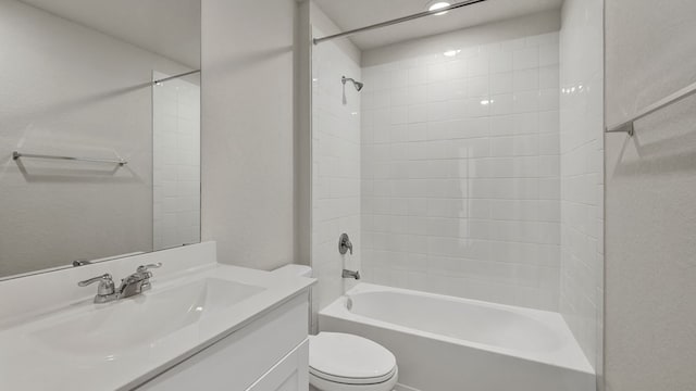 full bathroom with vanity, tiled shower / bath, and toilet