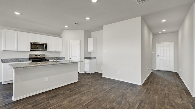 kitchen featuring white cabinetry, stainless steel appliances, dark hardwood / wood-style flooring, and a kitchen island with sink