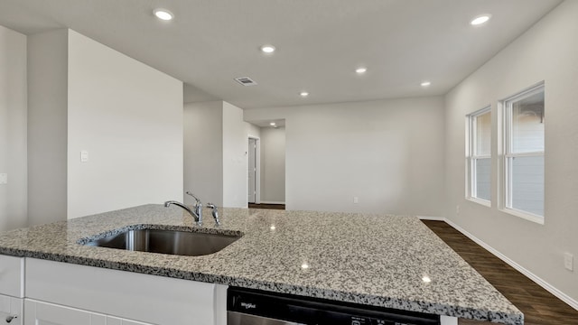 kitchen with white cabinets, sink, light stone countertops, and dishwasher