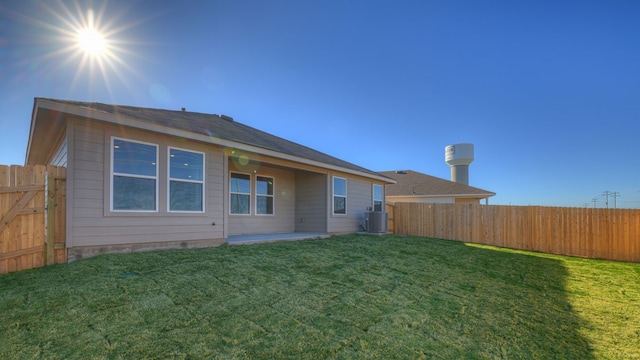 back of property featuring a yard and central air condition unit