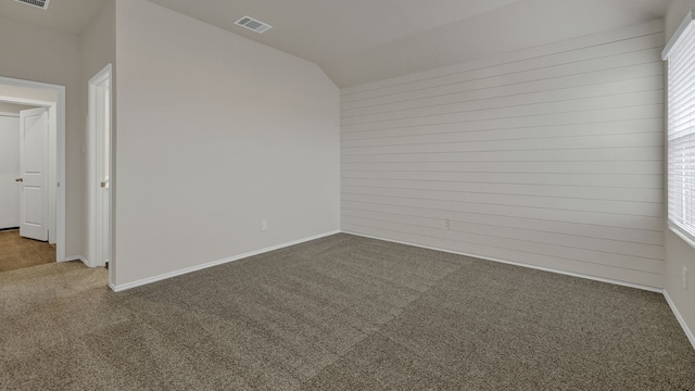 unfurnished room featuring vaulted ceiling and carpet floors