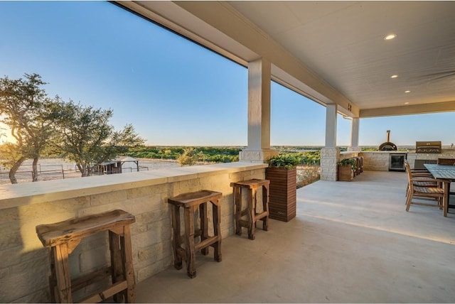 view of patio / terrace with an outdoor kitchen, area for grilling, and a bar