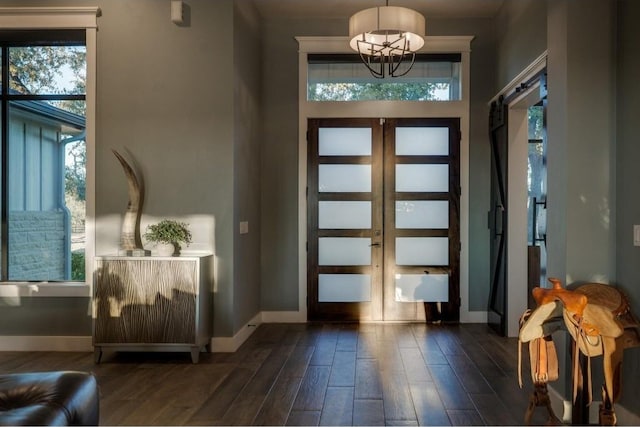 entryway featuring french doors, an inviting chandelier, and dark wood-type flooring