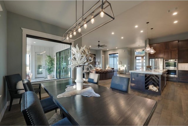 dining space featuring ceiling fan, a healthy amount of sunlight, and dark wood-type flooring