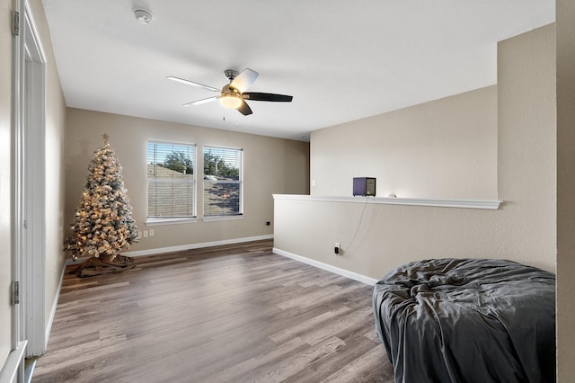 living area with ceiling fan and wood-type flooring