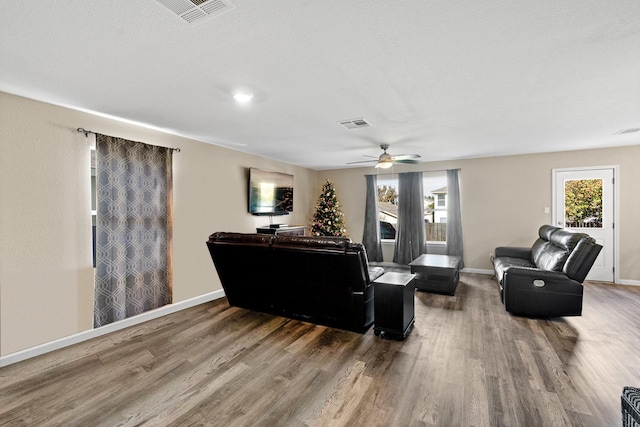 living room with a textured ceiling, hardwood / wood-style floors, and ceiling fan