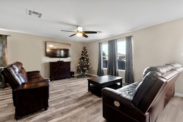 living room featuring ceiling fan and light hardwood / wood-style floors