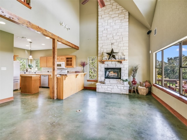 living room featuring high vaulted ceiling, ceiling fan, and a stone fireplace