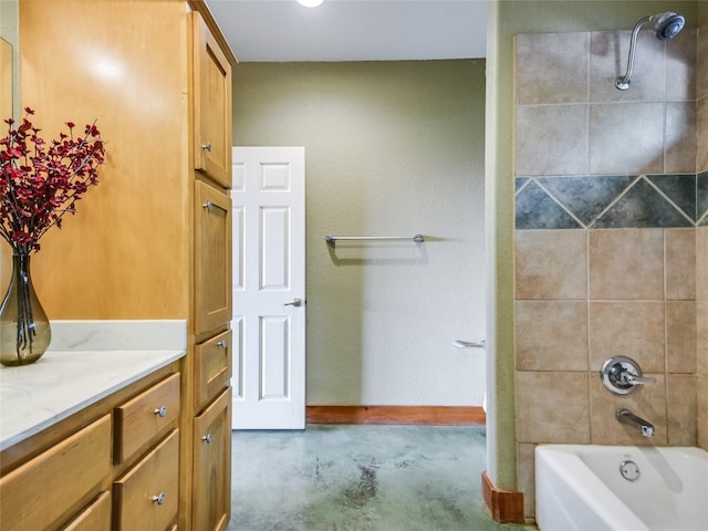 bathroom with tiled shower / bath combo, vanity, and concrete flooring