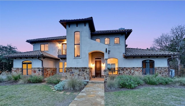 mediterranean / spanish-style house with a yard and a balcony