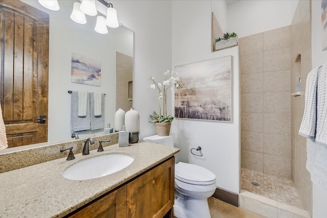 bathroom featuring vanity, tiled shower, a chandelier, and toilet