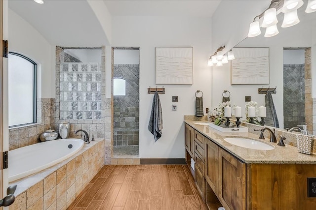 bathroom featuring hardwood / wood-style flooring, shower with separate bathtub, and vanity