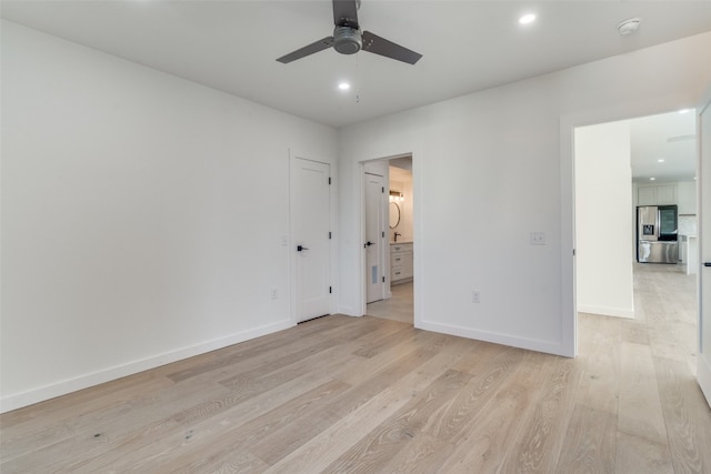 unfurnished bedroom with light hardwood / wood-style flooring, ceiling fan, ensuite bathroom, and stainless steel fridge with ice dispenser