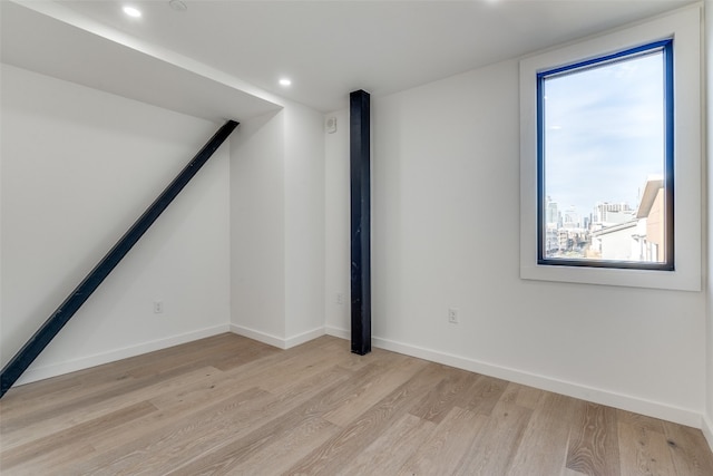 spare room with plenty of natural light and light hardwood / wood-style flooring